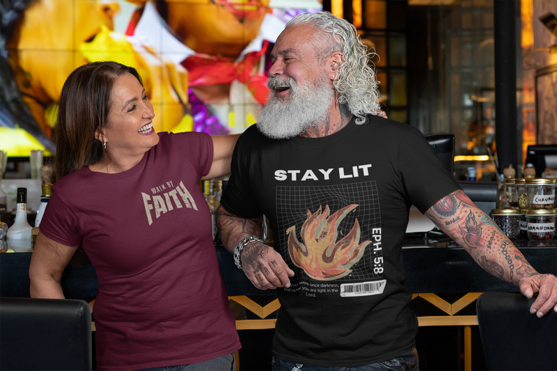 Couple wearing SeedSowerGraphics Christian apparel. The woman is wearing a maroon walk by faith shirt and the male is wearing a black stay lit Eph. 5:8 shirt