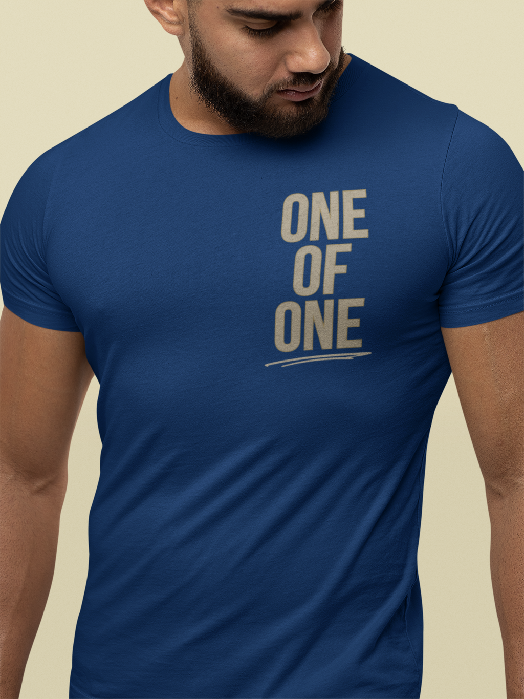 A man wearing a royal blue Christian graphic tee with the text 'ONE OF ONE' printed in a distressed beige font on the chest.