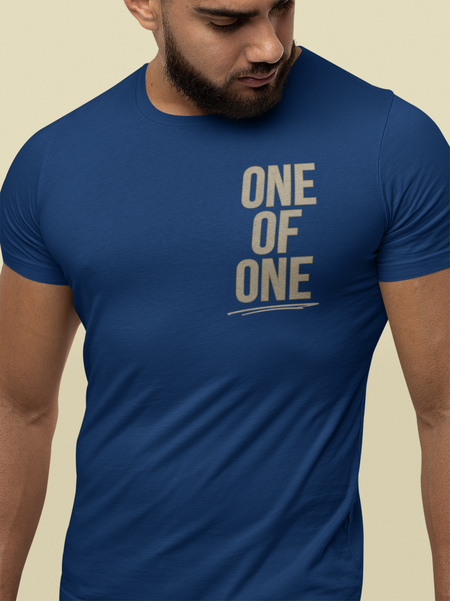 A man wearing a royal blue Christian graphic tee with the text 'ONE OF ONE' printed in a distressed beige font on the chest.