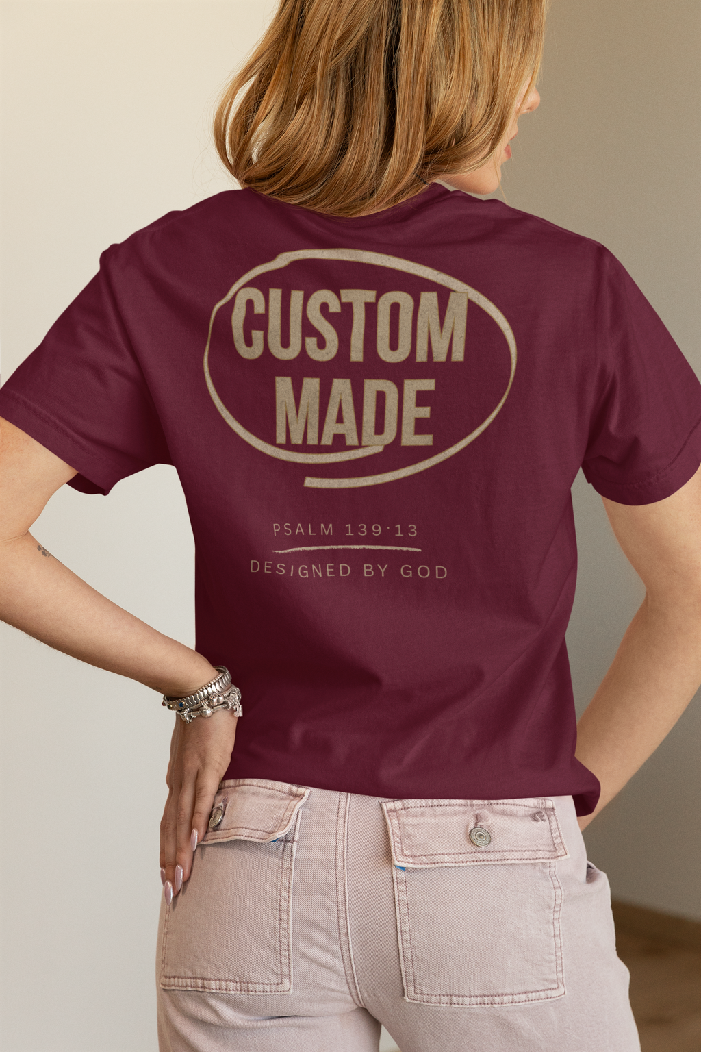A woman shown from the back wearing a maroon faith-based shirt that reads 'CUSTOM MADE' inside an oval, with smaller text below reading Psalm 139:13/ Designed by God.