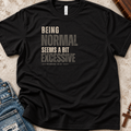 a black shirt that has monochrome black and gray lettering that says 'being normal seems a bit excessive' 'Romans 12:2"