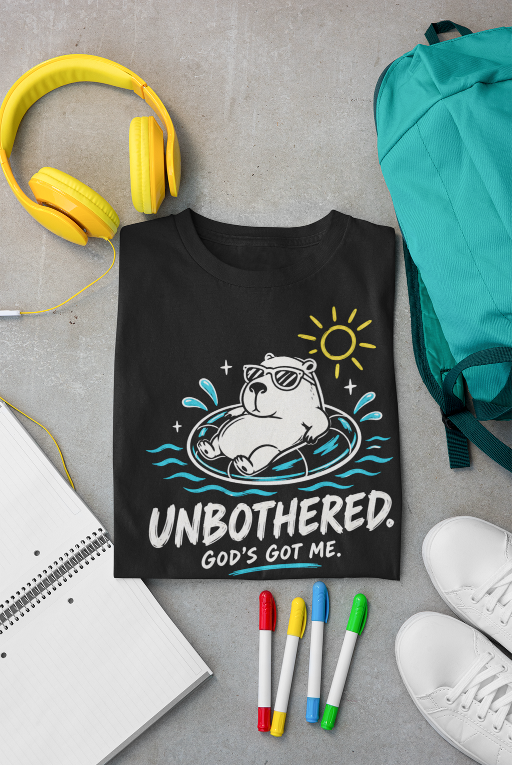 A black Christian graphic t-shirt by SeedSowerGraphics featuring a cartoon capybara in a pool float with the text 'UNBOTHERED. GOD'S GOT ME.