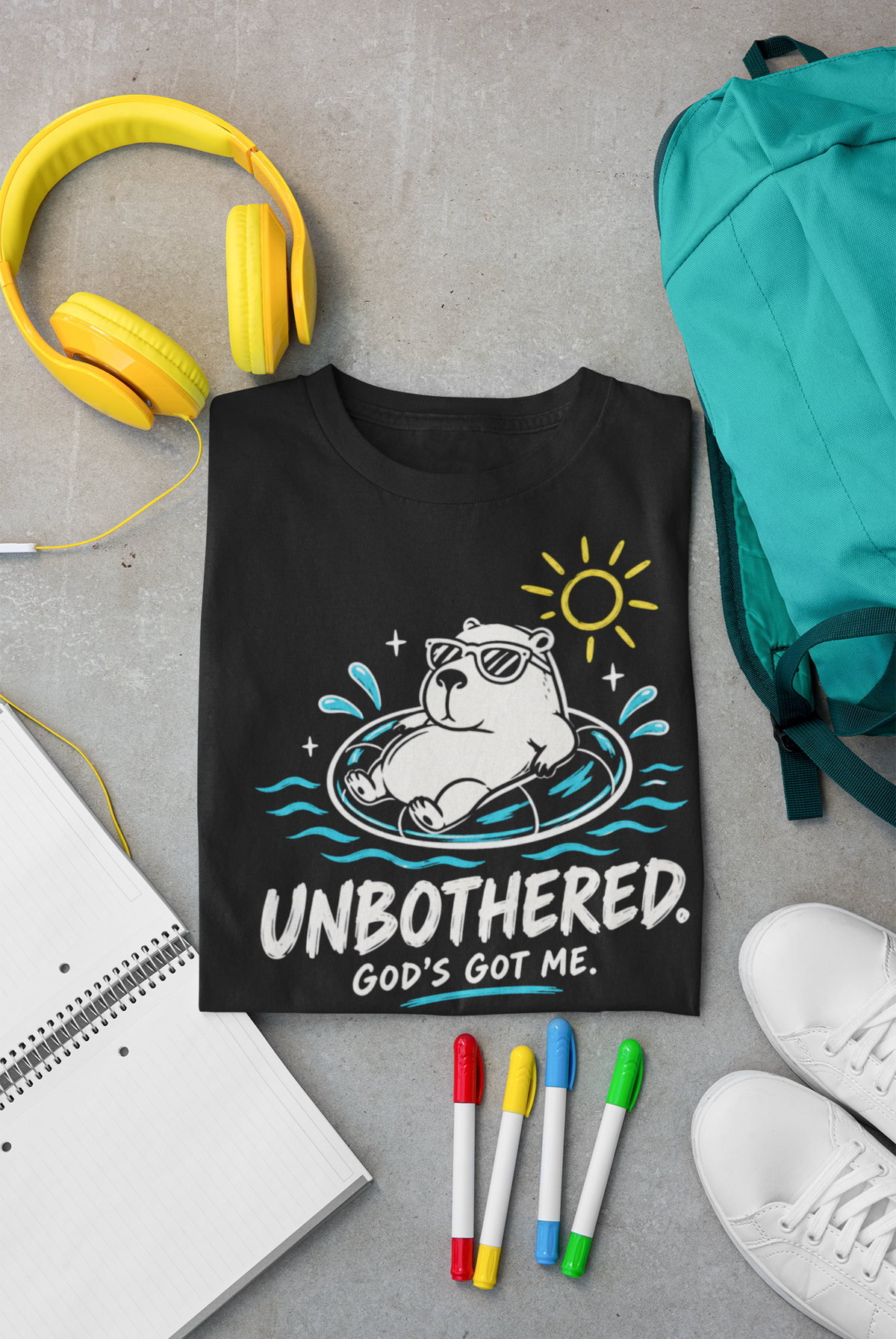 A black Christian graphic t-shirt by SeedSowerGraphics featuring a cartoon capybara in a pool float with the text 'UNBOTHERED. GOD'S GOT ME.