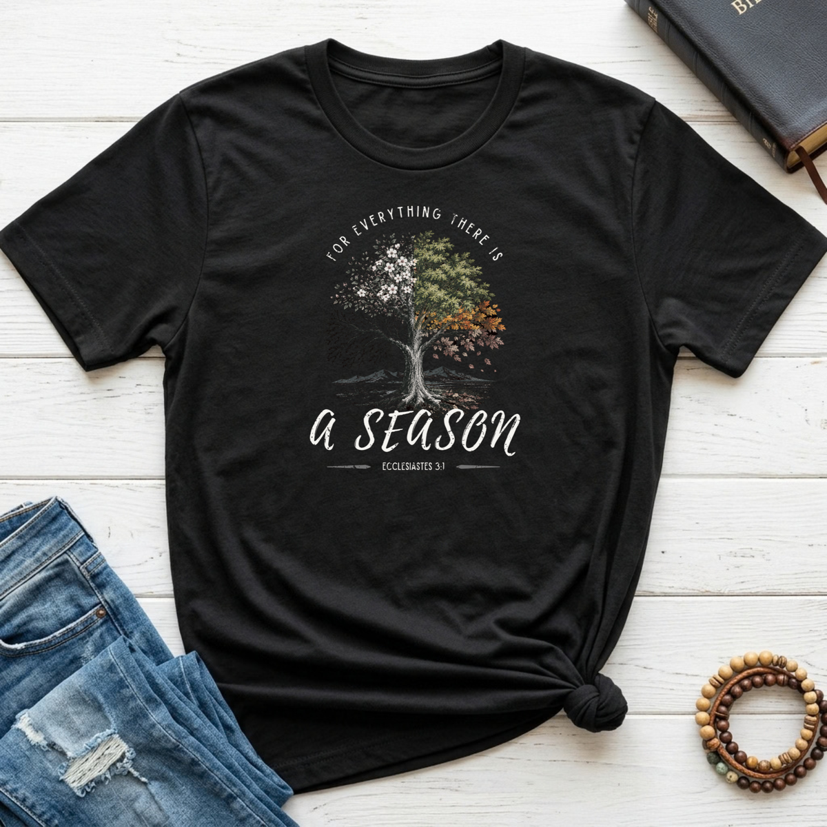 Black shirt with a tree portraying all the seasons with the words arched above it "for everything there is" and beneath the tree "a season' Ecclesiastes 3:1 