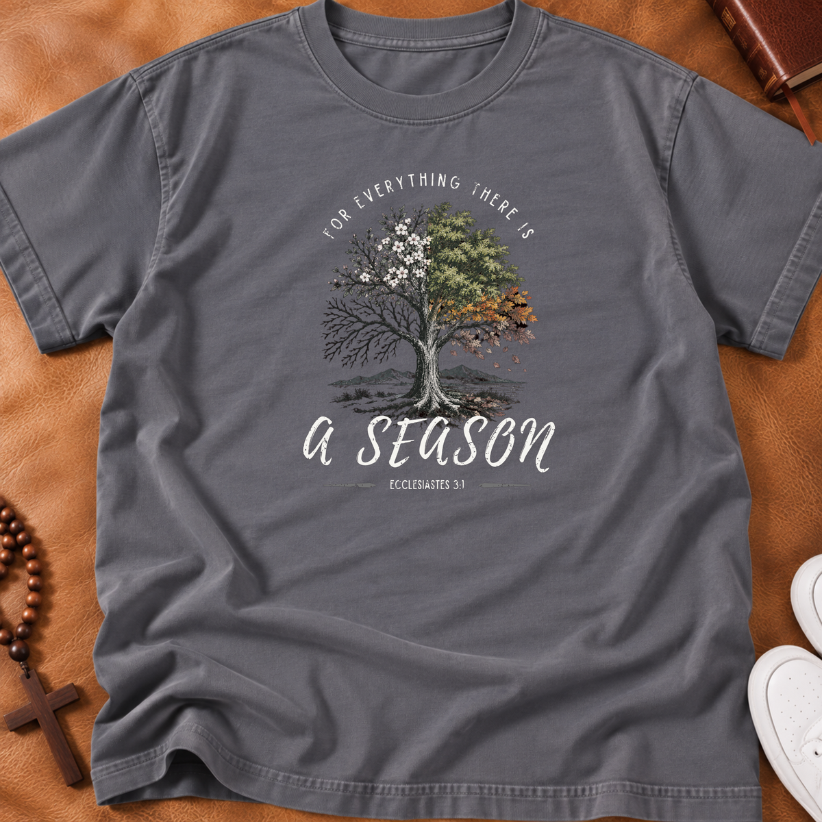 Grayish shirt with a tree portraying all the seasons with the words arched above it "for everything there is" and beneath the tree "a season' Ecclesiastes 3:1 