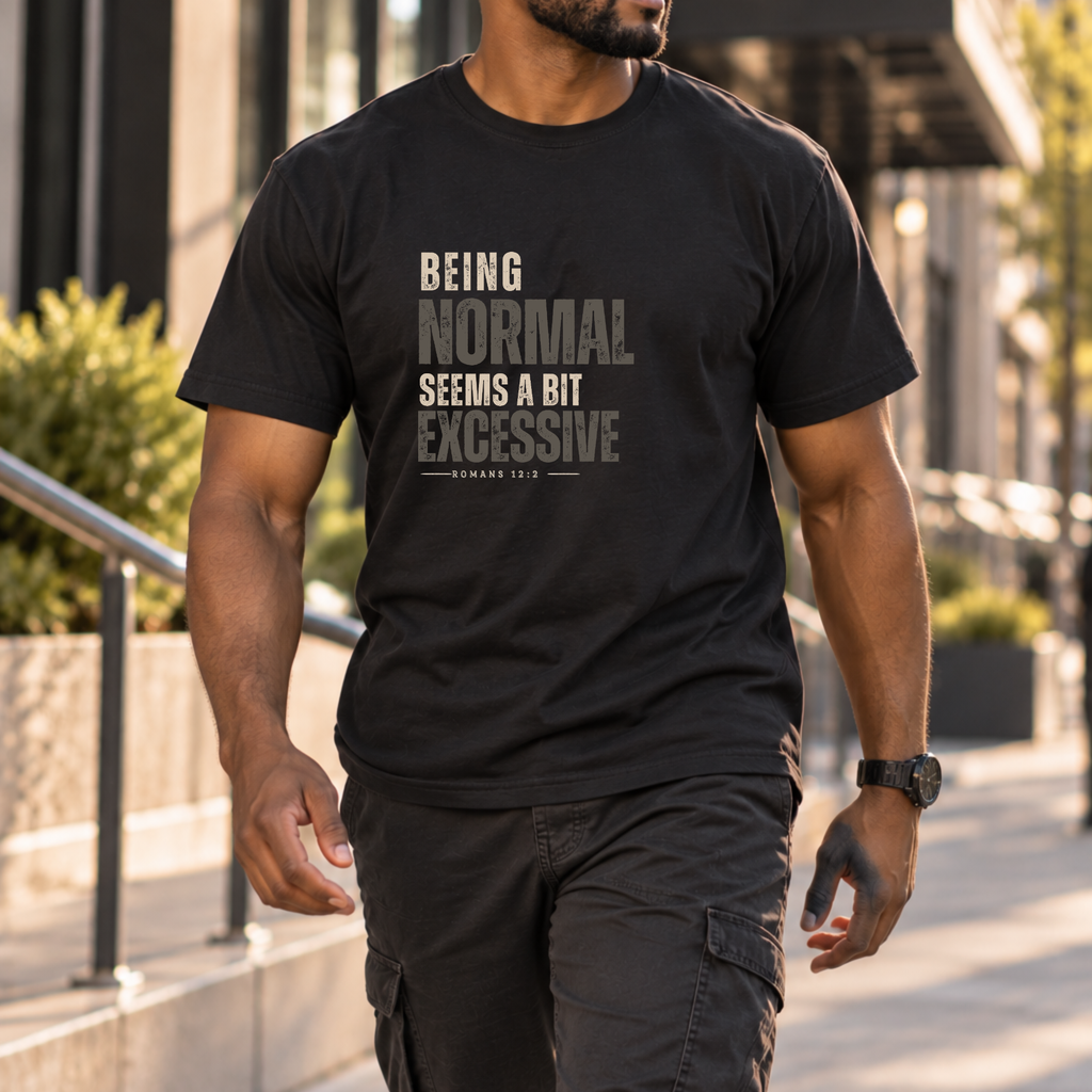 a man walking down a sidewalk wearing a black shirt that has monochrome black and gray lettering that says 'being normal seems a bit excessive' 'Romans 12:2"