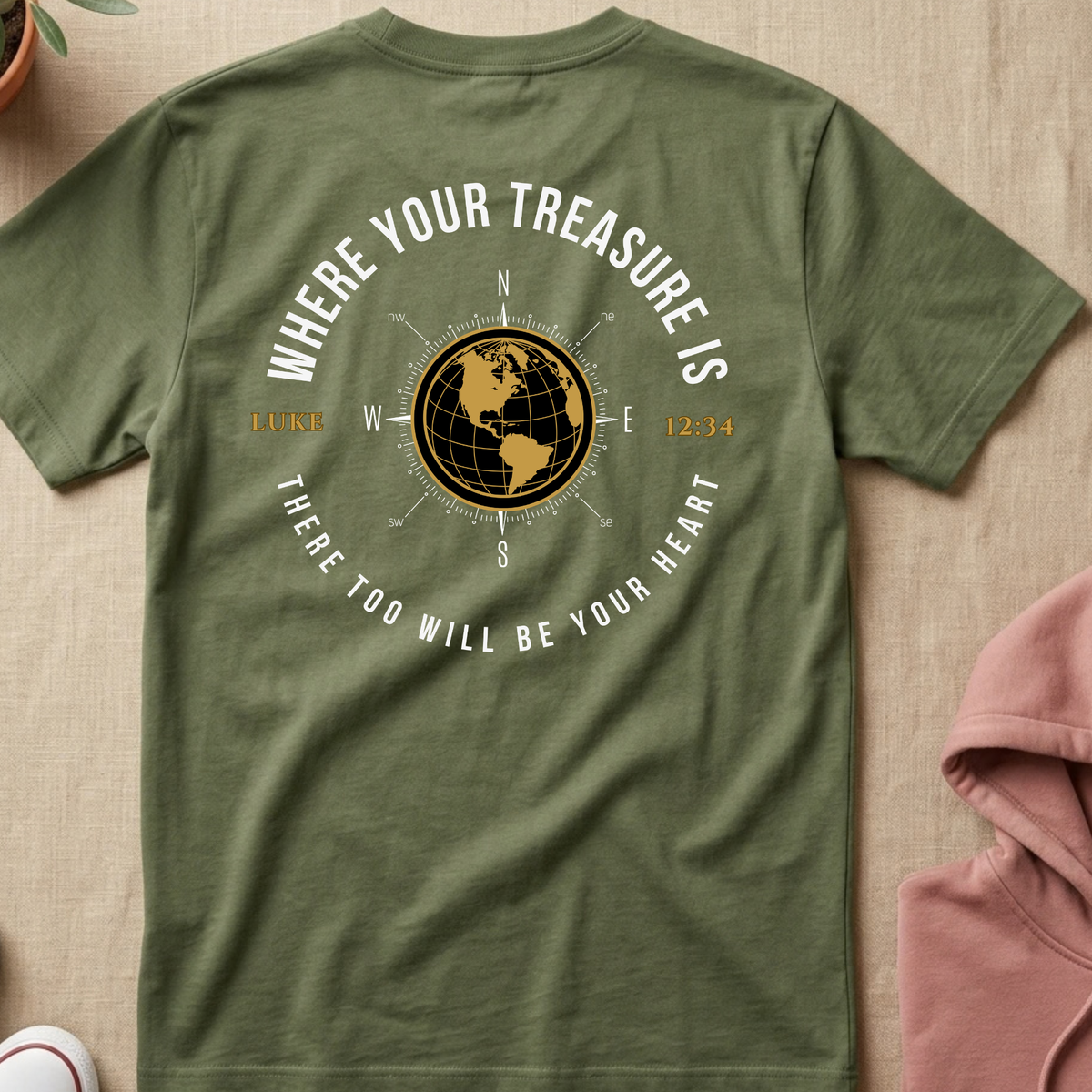  Military Green shirt with a graphic. The graphic features a gold globe compass, the text 'WHERE YOUR TREASURE IS' arched above, and 'THERE TOO WILL BE YOUR HEART' curved below, along with 'LUKE' and the time '12:34'.