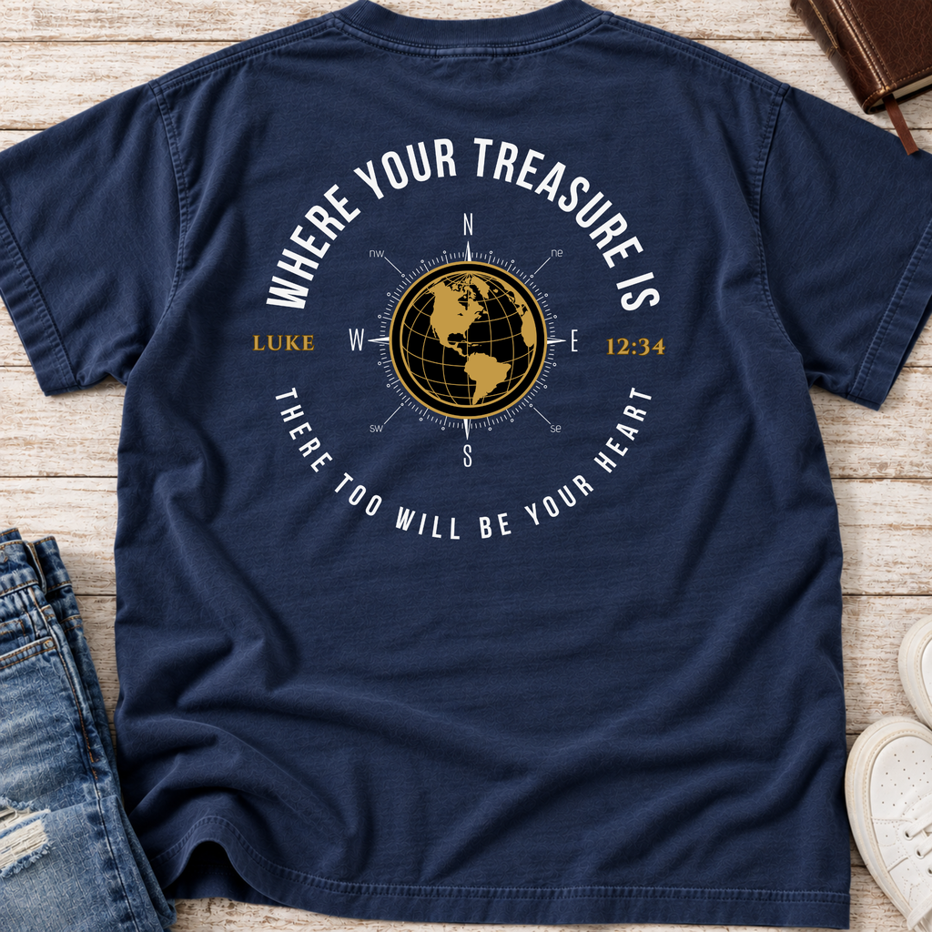 A navy blue shirt with a graphic on the back. The graphic features a gold globe compass, the text 'WHERE YOUR TREASURE IS' arched above, and 'THERE TOO WILL BE YOUR HEART' curved below, along with 'LUKE' and the time '12:34'.