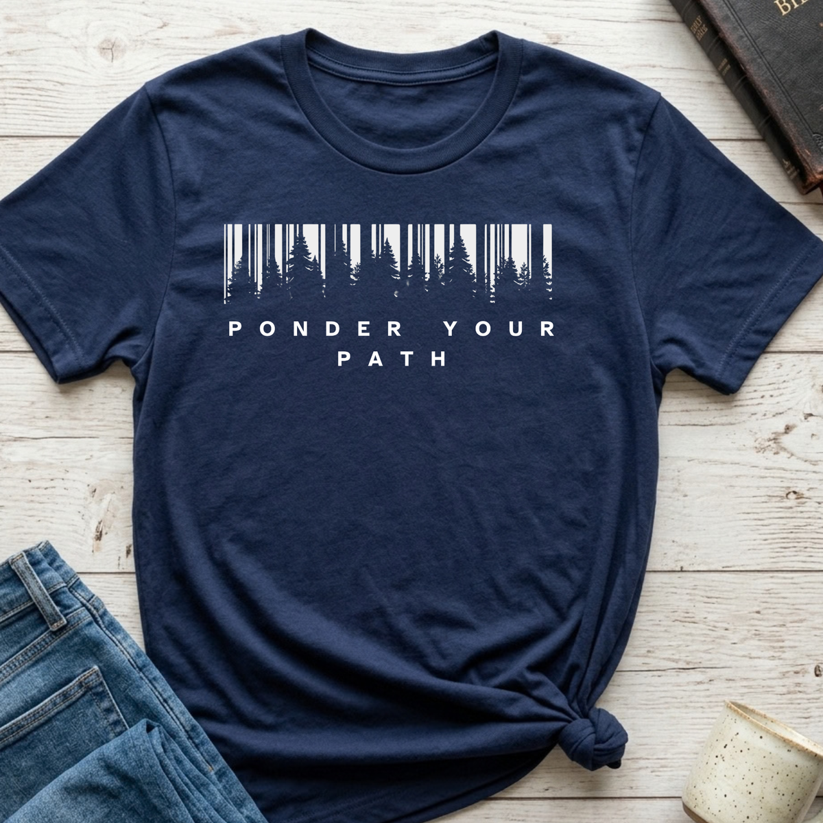 Navy Blue Shirt that has a graphic of a forest silhouette with white words underneath that says 'Ponder your Path'