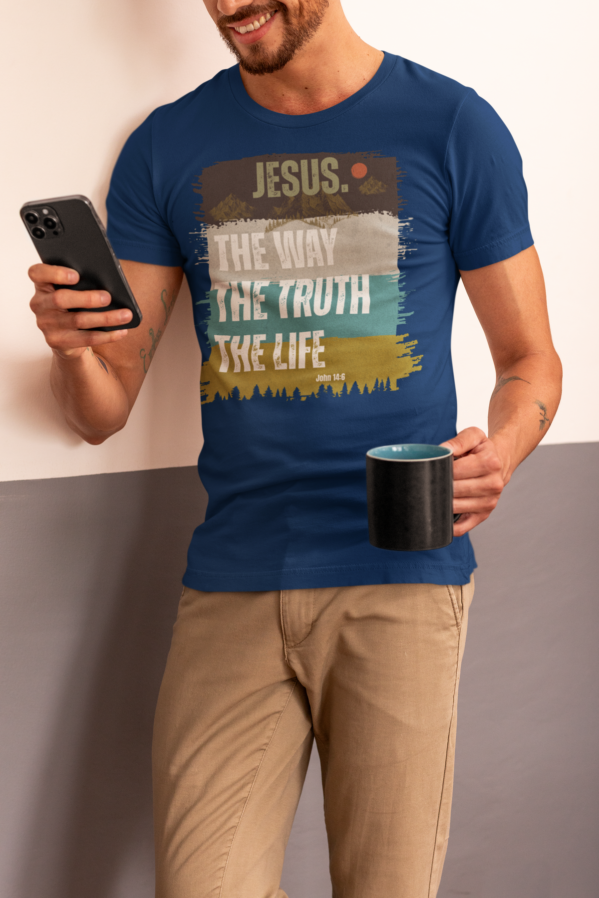 A man wearing a navy blue graphic t-shirt with the text 'JESUS. THE WAY THE TRUTH THE LIFE' in a distressed paint-stroke design.