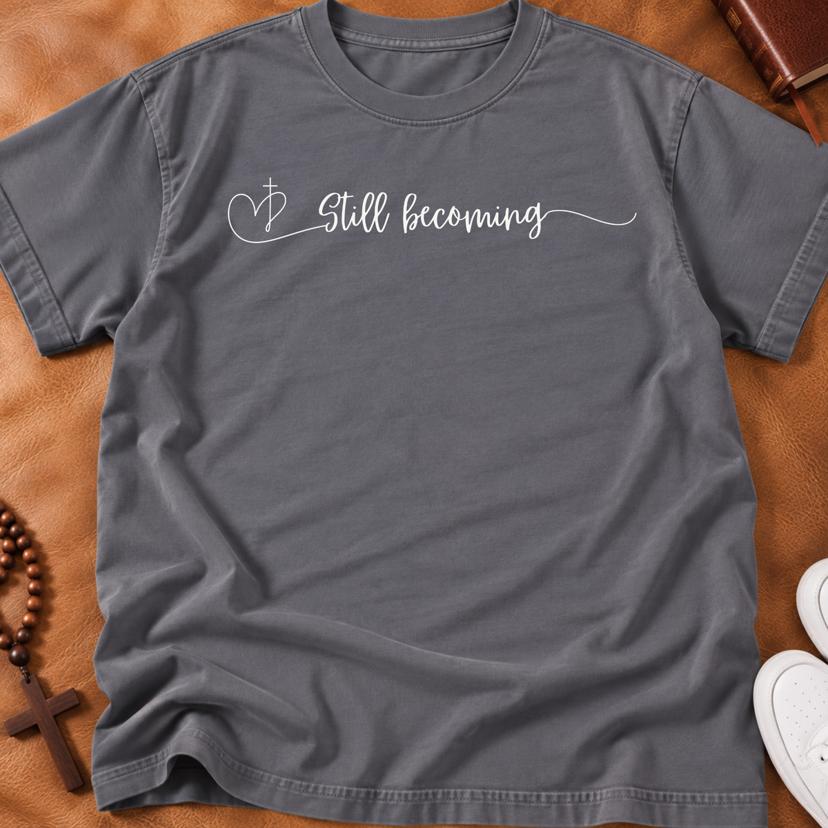 Storm colored shirt that says 'still becoming'