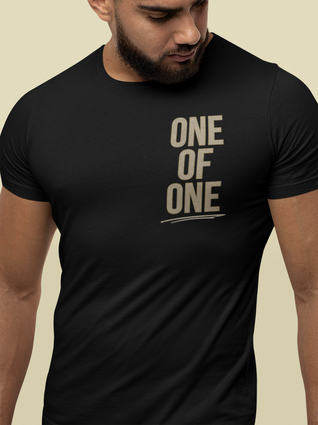 A man wearing a black faith-based conversation shirt that says 'ONE OF ONE' printed in a distressed beige font on the chest.