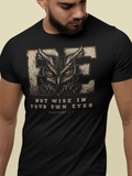 A man wearing a black short-sleeve Christian graphic t-shirt with a distressed owl design and the text 'BE NOT WISE IN YOUR OWN EYES Proverbs 3:7' on a light beige background.