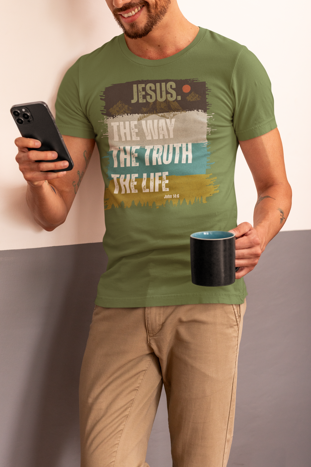A man wearing an olive green Christian graphic t-shirt with a distressed Christian-themed print that reads 'JESUS. THE WAY THE TRUTH THE LIFE' and 'JOHN 14:6'.