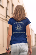 A woman viewed from behind wearing a royal blue Christian graphic t-shirt with a cream graphic print of a sailing ship and the text 'SEEK WISDOM AS Hidden Treasure'. 