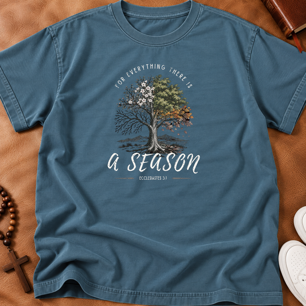 Steel Blue shirt with a tree portraying all the seasons with the words arched above it "for everything there is" and beneath the tree "a season' Ecclesiastes 3:1 