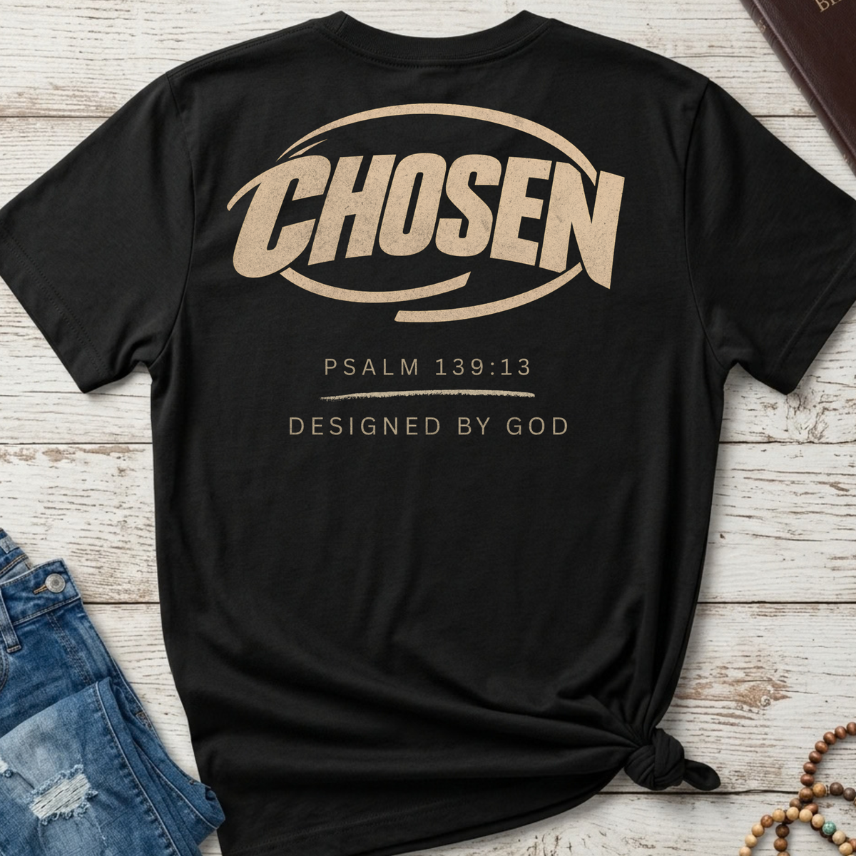 black shirt with the graphic that says Chosen in big goldish lettering and underneath psalm 139:2 and designed by God