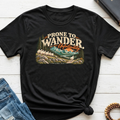 A black graphic t-shirt with a retro-style mountain and sheep illustration and the text 'PRONE TO WANDER. Unfortunately.