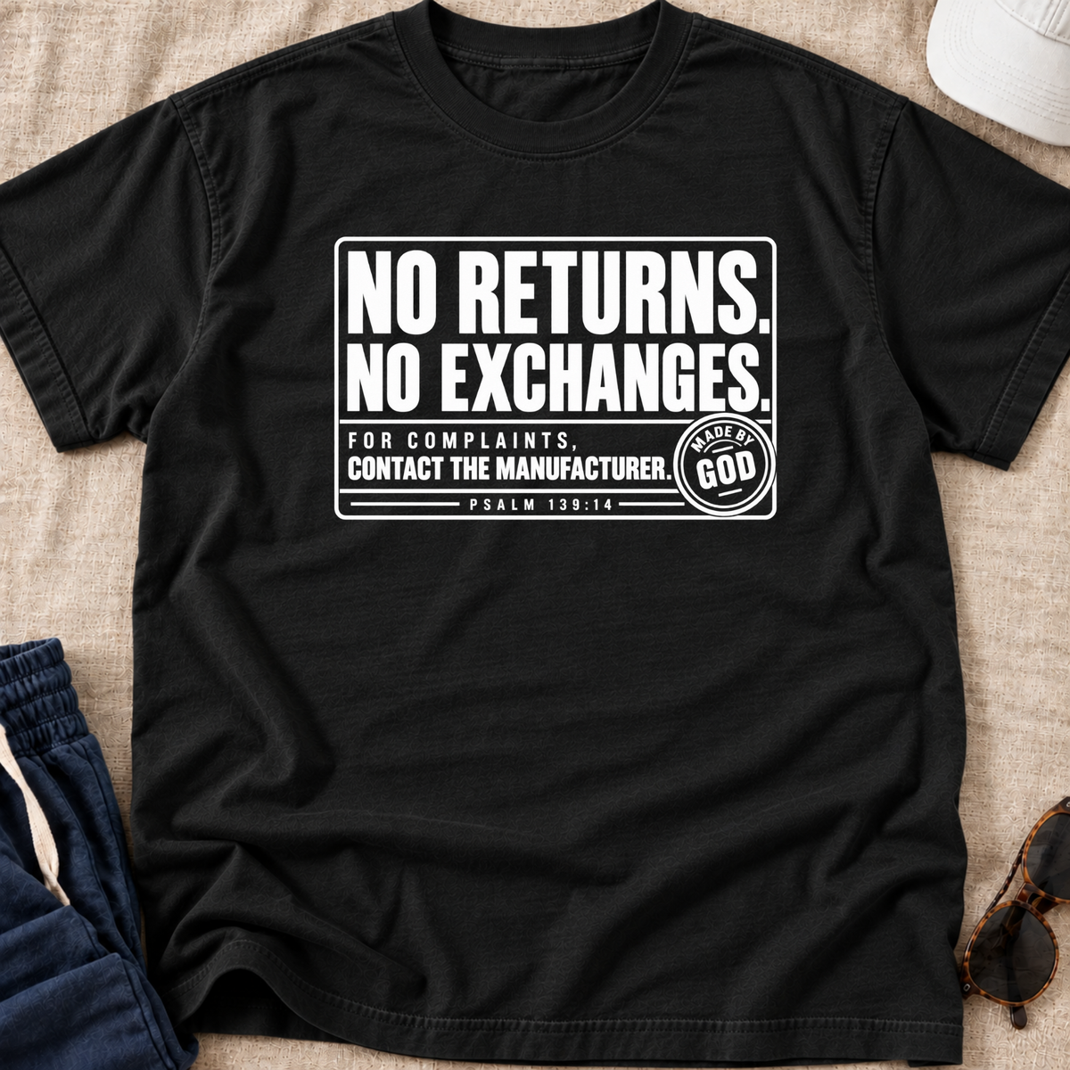 black christian youth shirt by SeedSowerGraphics laid out with white text that says "no returns. no exchanges. for complaints, contact the manufacturer' made by god' beneath it says psalm 139:14