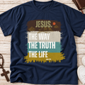 A navy blue graphic t-shirt laid flat on a light wood background, featuring a Christian-themed print with the text 'JESUS. THE WAY THE TRUTH THE LIFE' and 'AMOR I.